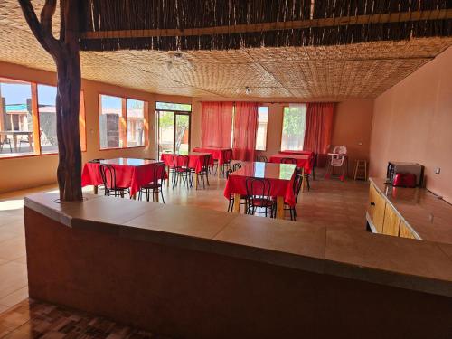 a dining room with red tables and chairs at Ckausama North in San Pedro de Atacama