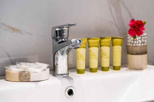 een gootsteen met een kraan en een rij gele kopjes bij Gkountis Deluxe King Suite 1 in Tsoukaladhes