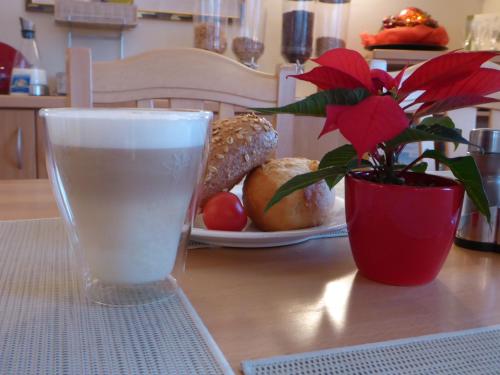a glass of water and a potted plant on a table at Hotel-Pension Scharl am Maibaum in Eitting