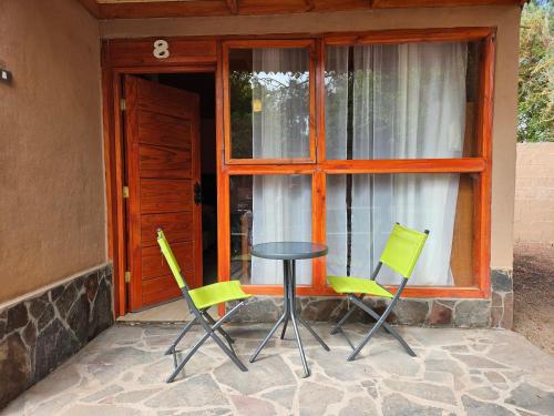 three chairs and a table in front of a window at Ckausama North in San Pedro de Atacama