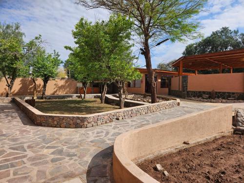 a garden with trees and a stone walkway at Ckausama North in San Pedro de Atacama
