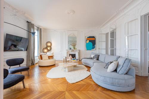 un salon avec un canapé bleu et une cheminée dans l'établissement Luxueux Appartement 5 BD, Arc de Triomphe, à Neuilly-sur-Seine