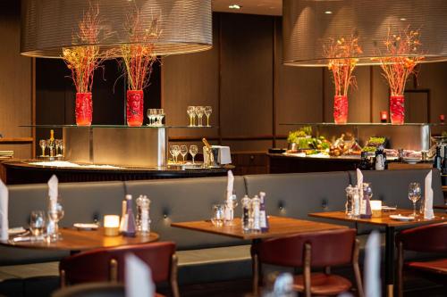 a restaurant with tables and chairs and lights at Frankfurt Airport Marriott Hotel in Frankfurt/Main