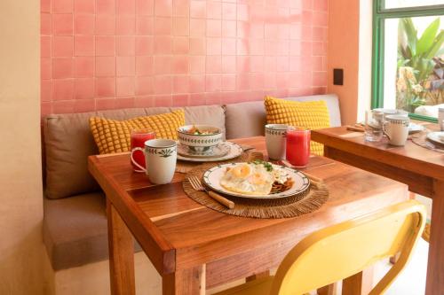 uma mesa de madeira com um prato de comida sobre ela em Kuka y Milpa em Mérida