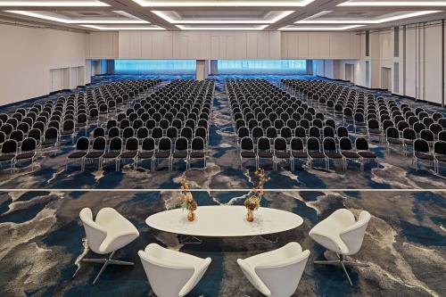 an empty hall with chairs and a white table and chairs at Frankfurt Airport Marriott Hotel in Frankfurt/Main