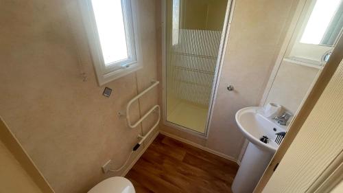 a bathroom with a toilet and a sink at PG69 Golden Palm 8 Berth Caravan with Decking in Chapel Saint Leonards