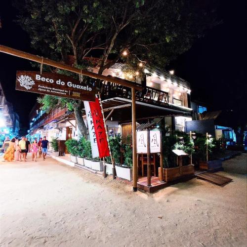 a building on a beach at night with people walking at Pousada Praiana Jericoacora in Jericoacoara