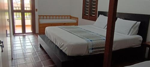 a bedroom with two beds and a sliding glass door at Royal-inn SPA & Pousada in Itanhaém