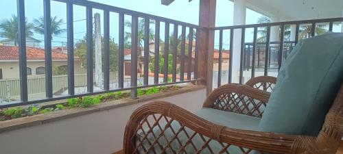 a rocking chair on a balcony with a view of a building at Royal-inn SPA & Pousada in Itanhaém