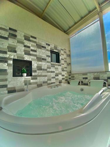 a large bath tub in a bathroom with a tv at Apartamento Familiar En Cartago in Marinita