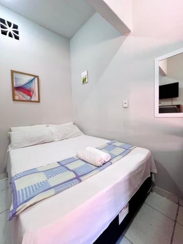 a small bedroom with a bed with a mirror at Pousada Praiana Jericoacora in Jericoacoara