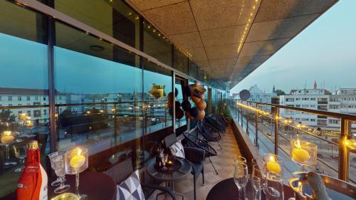a balcony of a restaurant with tables and candles at Aparthotel Market Square TectumApartments in Wrocław