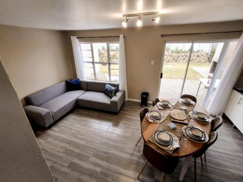 a living room with a couch and a table at Dune Whispers in Jeffreys Bay