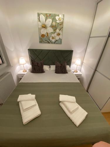 a bedroom with a large bed with two pillows at RED home in Banja Luka