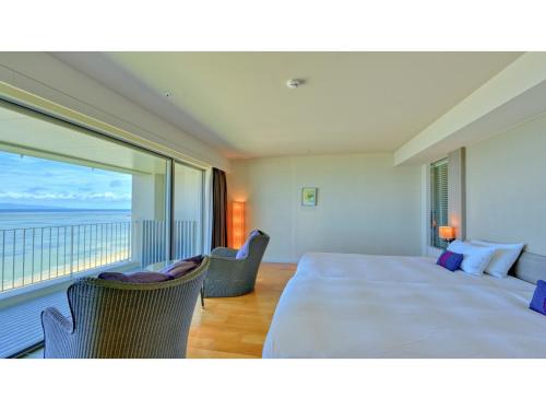 une chambre avec un grand lit et une grande fenêtre dans l'établissement Beach Hotel Sunshine Ishigakijima - Vacation STAY 95044v, à Ishigaki