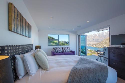 a bedroom with a large bed with a large window at Alpine Edge Villa- AC- Free Parking- Hot Tub- BBQ in Queenstown