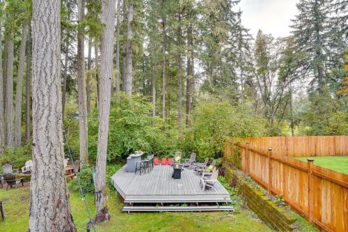 a backyard with a wooden deck with a table and chairs at Hot Tub and Fireplace Peaceful Anderson Island Home in Johnson Landing