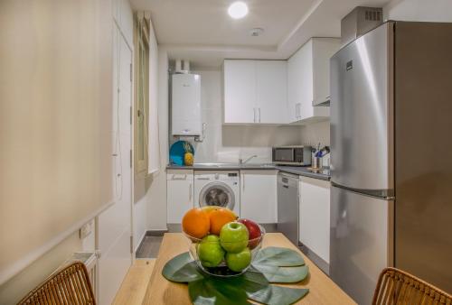 a kitchen with a table with a bowl of fruit on it at Slow Suites Luchana in Madrid