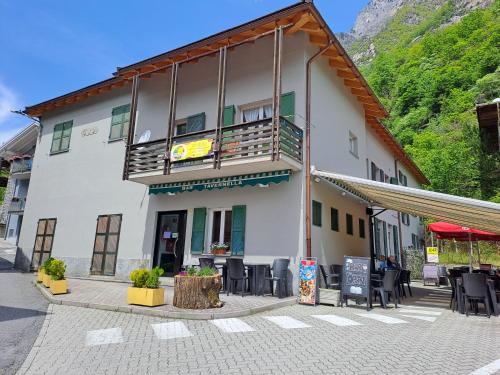 a building with tables and chairs in front of it at Casa Vacanze Tavernella di Pam in Villa di Chiavenna
