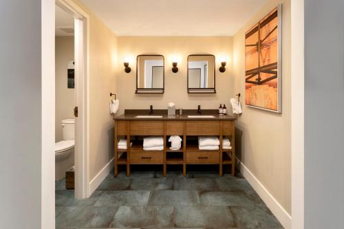 a bathroom with a sink and two mirrors at The Perry Hotel & Marina Key West in Key West