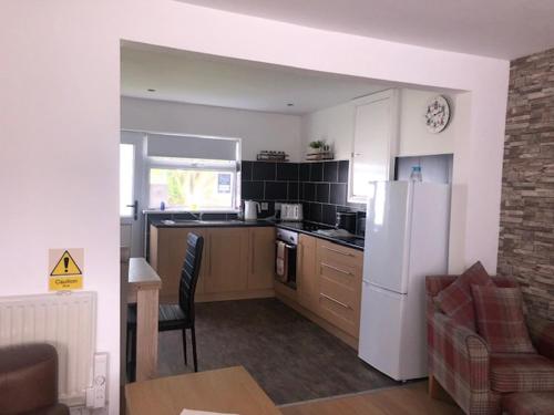 a kitchen with a white refrigerator and a table at Chalet 147 South Shore Bridlington in Bessingby