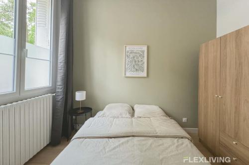 une chambre avec un lit et une fenêtre dans l'établissement Flexliving - 99 Felix Faure - Whole apartment, à Paris