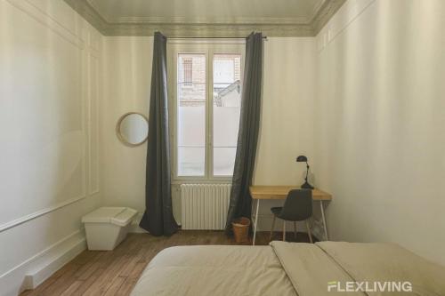 une chambre avec un lit, un bureau et une fenêtre dans l'établissement Flexliving - 99 Felix Faure - Whole apartment, à Paris