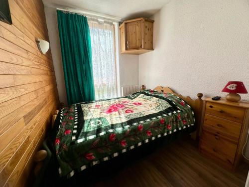 une chambre avec un lit avec une couette dessus dans l'établissement Résidence Carroley A - 2 Pièces pour 4 Personnes 48, à Mâcot La Plagne