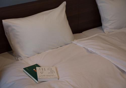 un libro sentado en la parte superior de una cama en BOOKHOTEL Kyoto Kujo - Vacation STAY 95401v, en Kioto