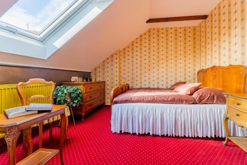 ein Schlafzimmer mit einem Bett, einem Schreibtisch und einem Fenster in der Unterkunft Dům U Pana domácího in Zlín