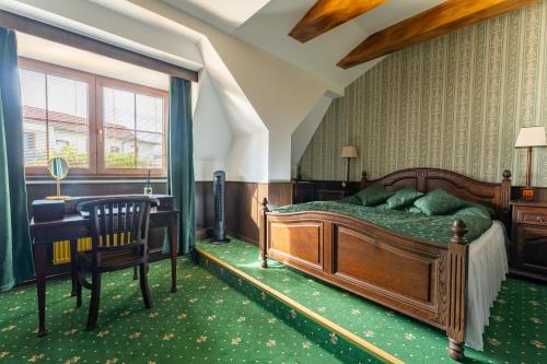 ein Schlafzimmer mit einem Bett, einem Schreibtisch und einem Stuhl in der Unterkunft Dům U Pana domácího in Zlín