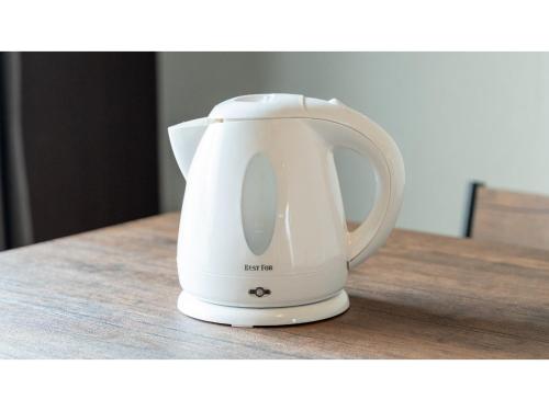 a white electric kettle sitting on a wooden table at HOTEL Progress inn Nago MATABee - Vacation STAY 01594v in Nago