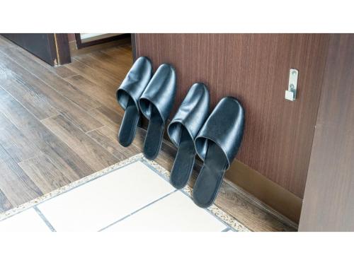 a row of black shoes hanging on a door at HOTEL Progress inn Nago MATABee - Vacation STAY 01594v in Nago