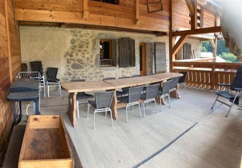 Une grande table et des chaises en bois sont disponibles sur la terrasse. dans l'établissement Chalet nant lovi, à Saint-Jean-de-Sixt