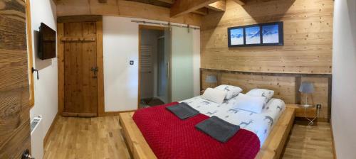 Cette chambre en bois comprend un grand lit. dans l'établissement Chalet nant lovi, à Saint-Jean-de-Sixt
