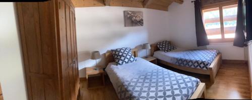 une petite chambre avec deux lits et une fenêtre dans l'établissement Chalet nant lovi, à Saint-Jean-de-Sixt