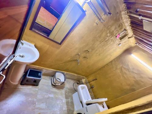 a small bathroom with a toilet and a sink at La Pahi Palace- Banquet and Resort in Sakri