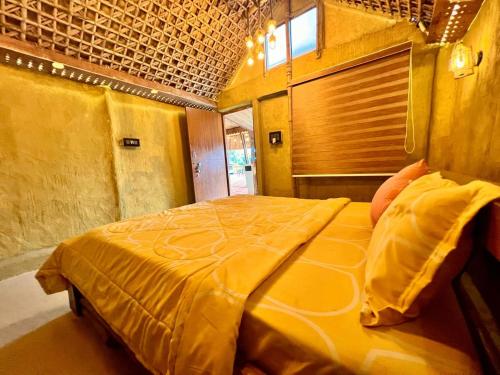 a large yellow bed in a room with a window at La Pahi Palace- Banquet and Resort in Sakri