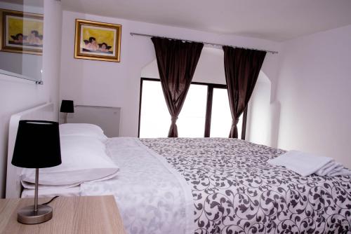 sypialnia z białym łóżkiem i oknem w obiekcie B&B Il Tramontano w mieście Matera