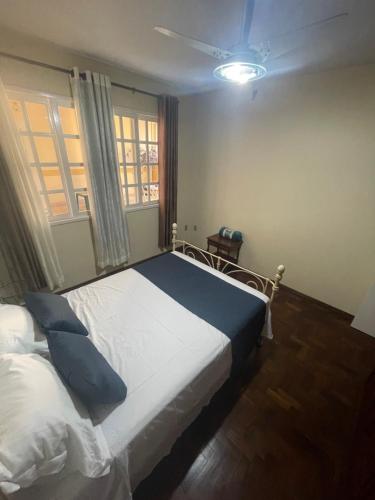 a bedroom with a large white bed with blue pillows at Casarão DM in Domingos Martins