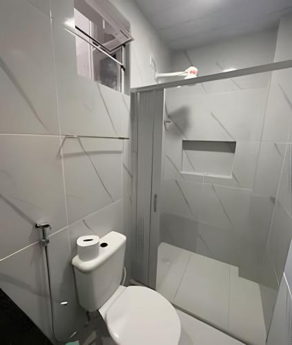 a white bathroom with a toilet and a window at Residencial JC II sua casa em Belém do Pará in Belém