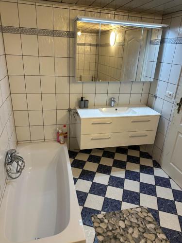 a bathroom with a tub and a sink and a mirror at Hotel AS in Kassel