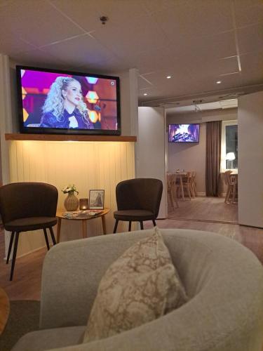 a living room with a flat screen tv on the wall at Hotell Rådhuset in Lidköping