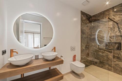 a bathroom with two sinks and a mirror at Villa Blue Bay Curacao in Sint Michiel
