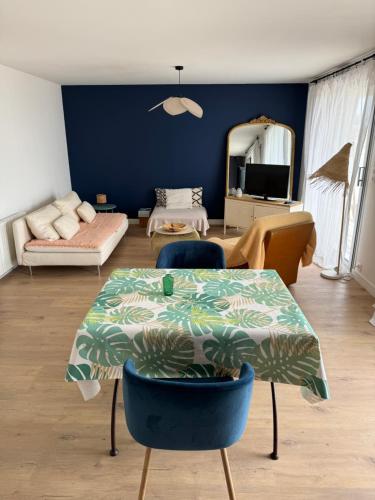 un salon avec une table et un canapé dans l'établissement Appartement cosy face à la mer, à Larmor-Plage