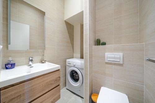 a bathroom with a washing machine and a sink at 1-BR Monaco Apartment - 1 minute to Monaco in Beausoleil