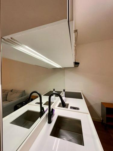 a kitchen counter with two sinks and a kitchenilit at Flat Moderno no Coração do Rio in Rio de Janeiro
