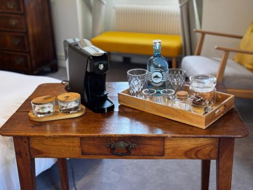 a table with a bottle of whiskey and glasses on it at Les Vieilles Digues in Beauvoir