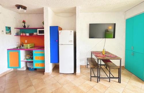 a kitchen with a table and a refrigerator in a room at Cancun Studio - Steps to Beach and Water Fun in Cancún