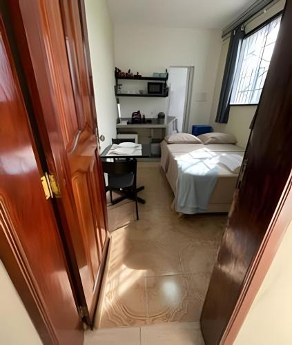 a bedroom with a bed and a desk and a table at Residencial JC II sua casa em Belém do Pará in Belém